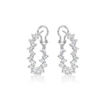 The Zigzag Emerald Cut Diamond Hoops are 18K white gold earrings featuring clear, emerald-cut diamonds arranged around the hoops and secured with a top clasp, shown on a white background.