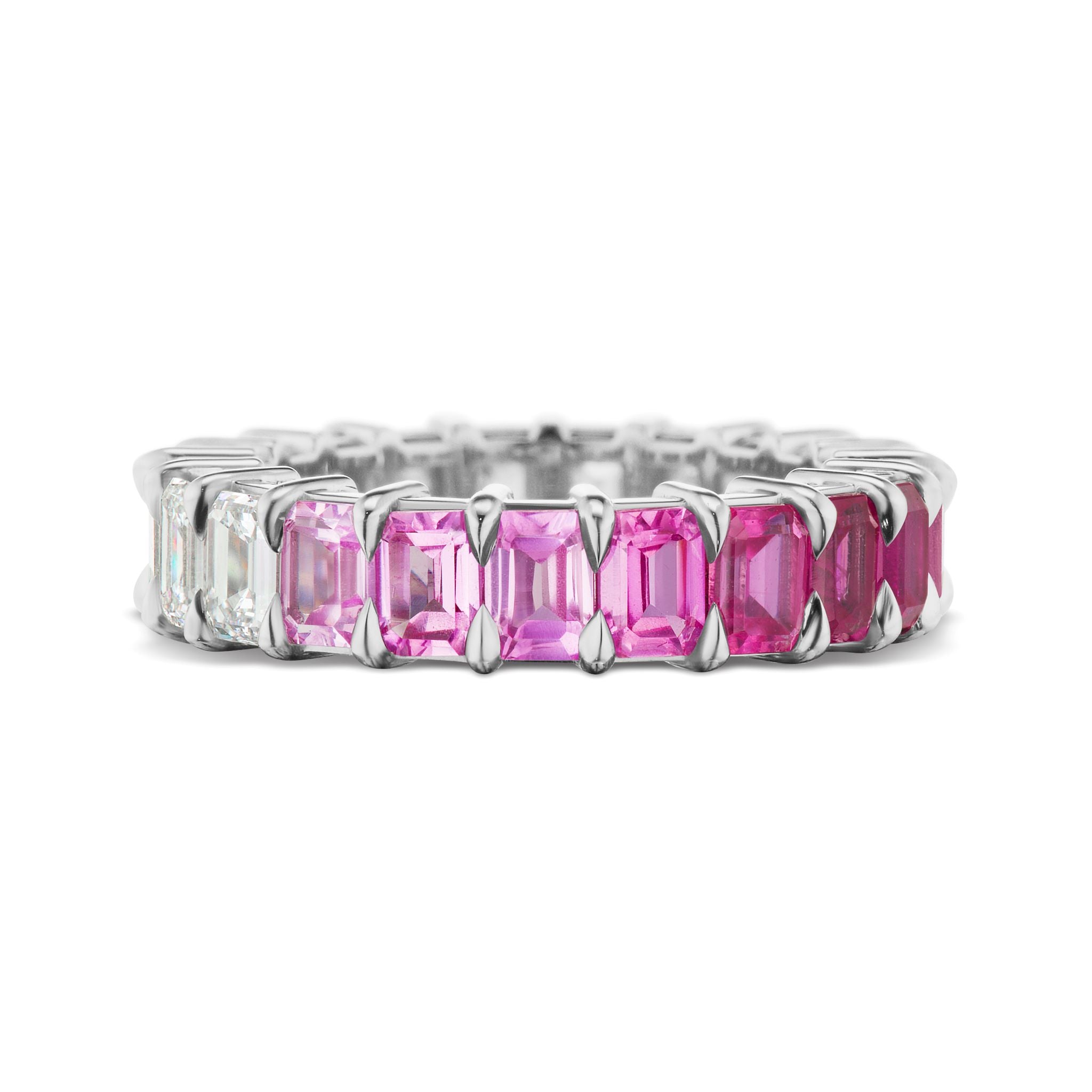 The Ombré Eternity Band features emerald-cut pink sapphires and white diamonds in a gradient from clear to deep pink, set in silver prongs around the band.