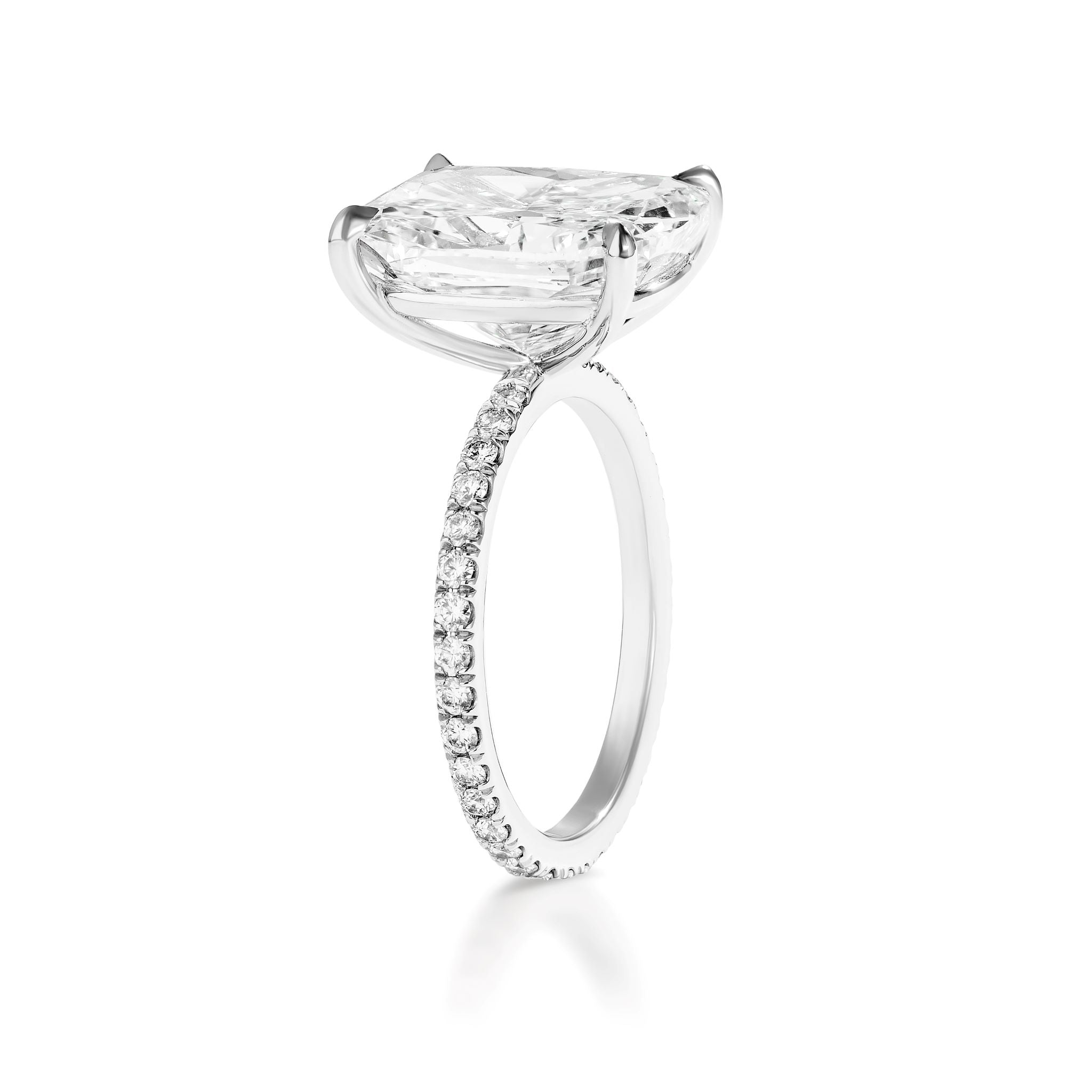 Side view of the Cushion Cut Diamond Engagement Ring with Pavé Band, showcasing a large cushion-cut solitaire held by four prongs and small round diamonds set along a slender white gold band.