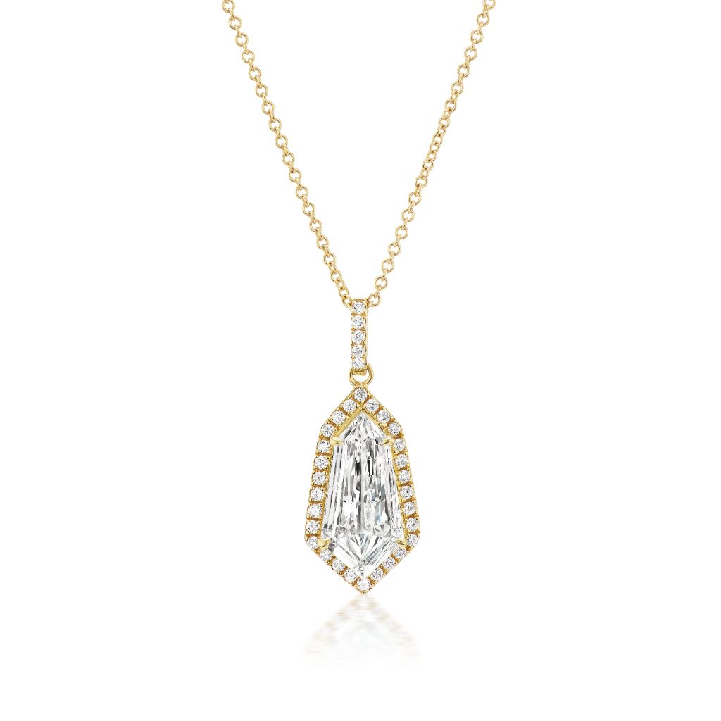 The Shield Cut Diamond Pavé Pendant in Yellow Gold features a geometric shield cut diamond with pavé accents on a delicate yellow gold chain, shown against a white background.