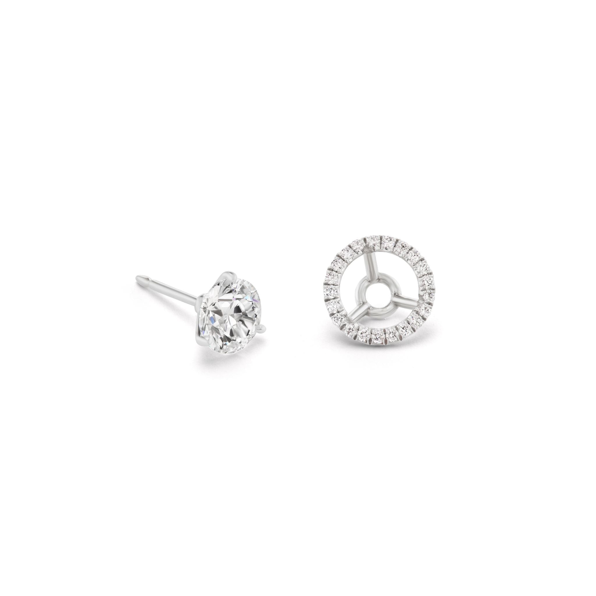 The Pavé Halo Ear Jackets in Platinum with Round Brilliant Diamonds feature one stud with a single round diamond and another with a circular platinum ear jacket adorned with pavé-set diamonds.