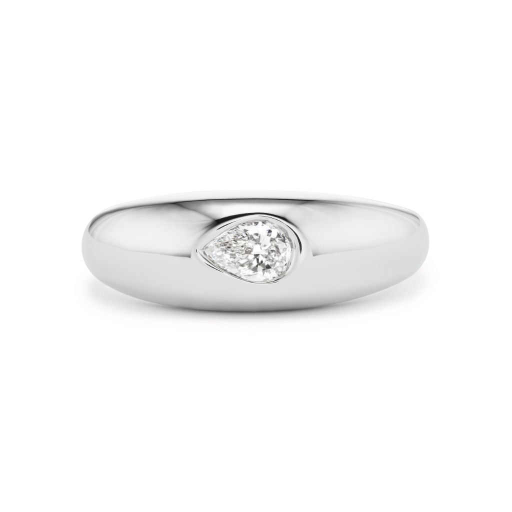 The Dome Ring in White Gold with Pear Diamond showcases a polished 18K white gold dome, elegantly set with a single pear-shaped diamond at its center.