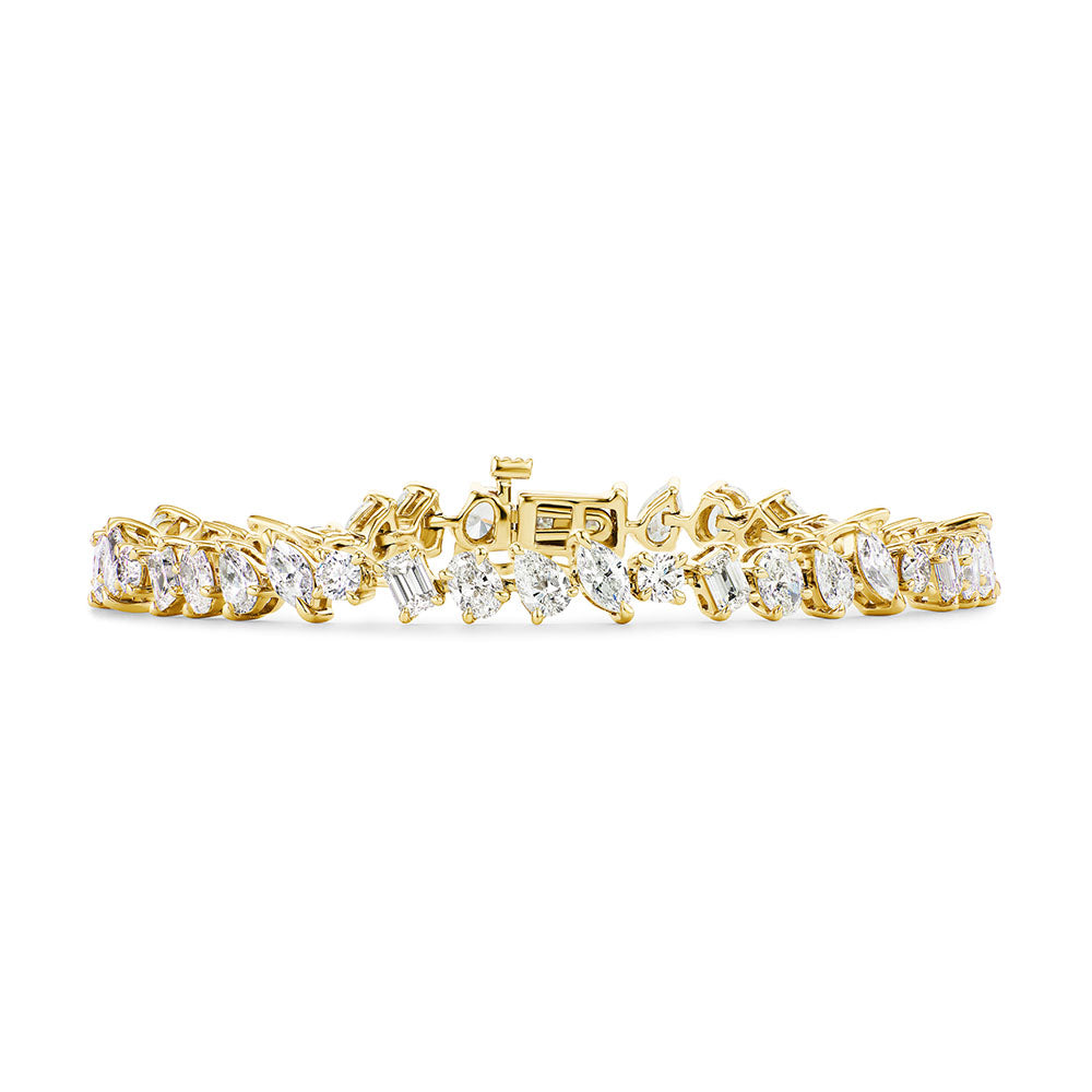 The Mixed Shape Diamond Tennis Bracelet features round, oval, and marquise diamonds set in 18k gold with a secure clasp, creating an elegant repeating pattern.
