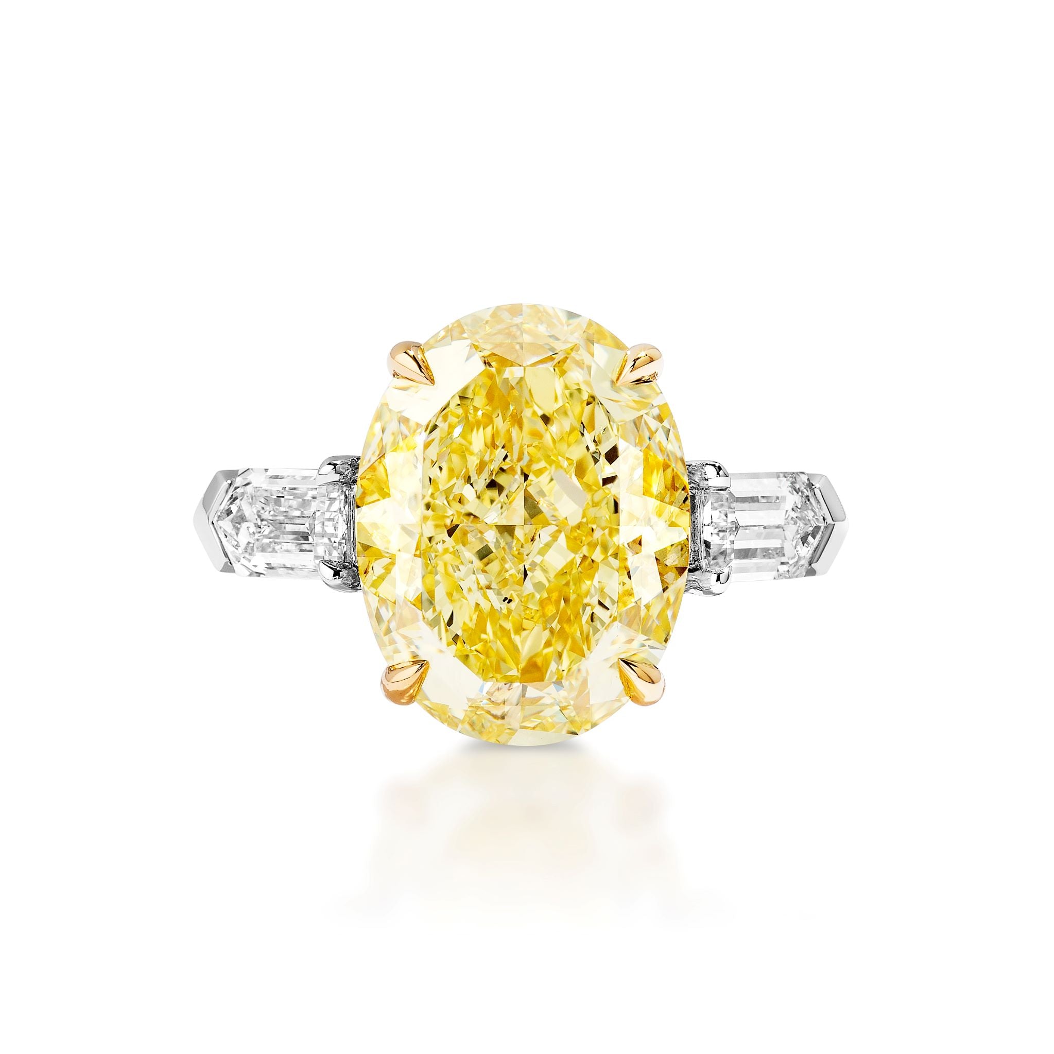 The Fancy Yellow Oval Diamond Engagement Ring with Bullet Side Stones features a yellow oval diamond in gold prongs, bullet-shaped white diamonds on each side, and a platinum band shown against a white background.